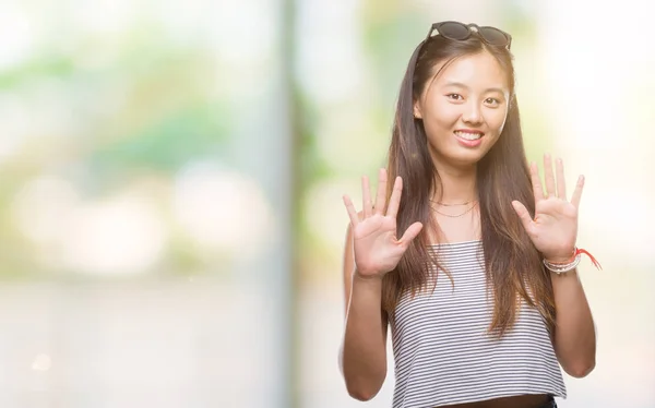 年轻的亚洲妇女在孤立的背景显示与手指十号 — 图库照片