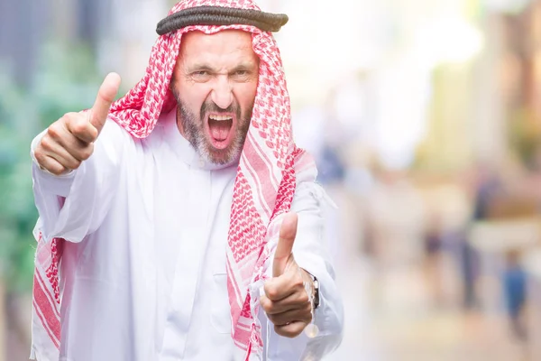 阿拉伯的资深男子穿着 Keffiyeh 在孤立的背景 赞成做积极的手势用手 竖起大拇指微笑 并为成功高兴 看着镜头 赢家的手势 — 图库照片