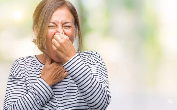 中年高级西班牙裔妇女在与世隔绝的背景下闻到一些臭味和恶心 难以忍受的气味 用手指在鼻子上屏住呼吸 坏气味概念 — 图库照片