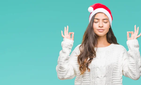 孤立した背景の上身に着けているクリスマスの帽子を若いアラブ女性のリラックスし 瞑想の指ジェスチャーをやって閉じた目を浮かべてします ヨガの概念 — ストック写真