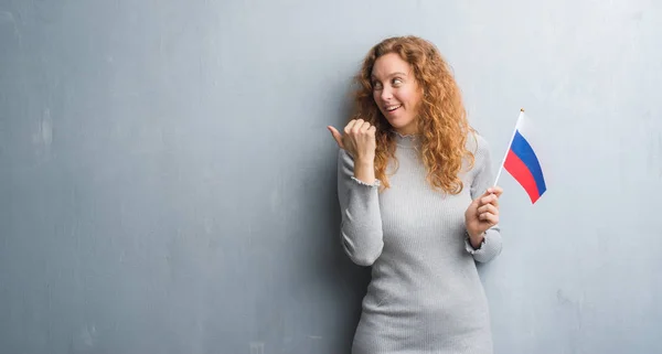 Giovane Donna Rossa Sopra Grigio Grunge Muro Tenendo Bandiera Della — Foto Stock