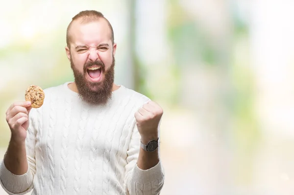 Unga Hipster Mannen Äter Choklad Chips Cookie Över Isolerade Bakgrund — Stockfoto