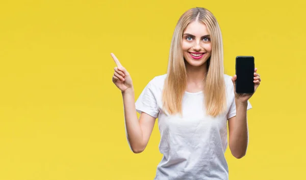 Mladá Krásná Blondýnka Ukazuje Smartphone Izolované Pozadí Velmi Spokojený Rukou — Stock fotografie