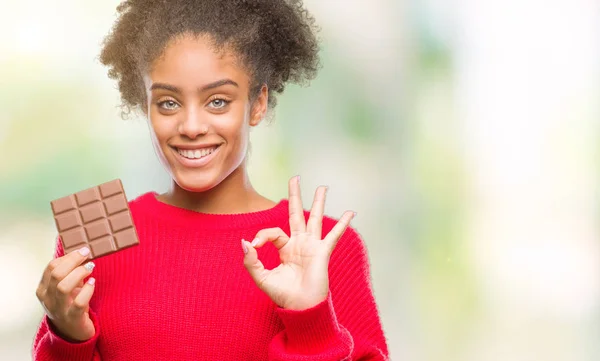 Junge Afroamerikanerin Isst Schokoriegel Über Isoliertem Hintergrund Tut Zeichen Mit — Stockfoto