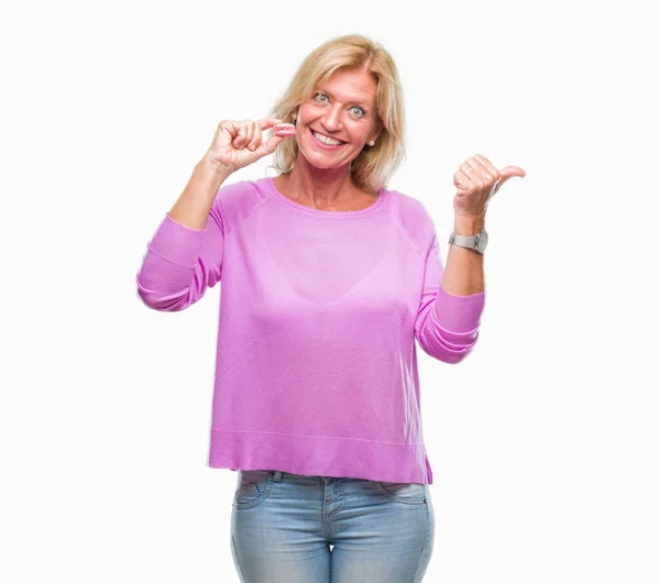 Mujer Rubia Mediana Edad Comiendo Galleta Macaron Rosa Sobre Fondo — Foto de Stock