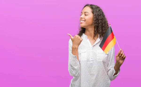 Młoda Hiszpanin Kobieta Gospodarstwa Banderą Niemiec Wskazując Wyświetlono Kciukiem Boku — Zdjęcie stockowe