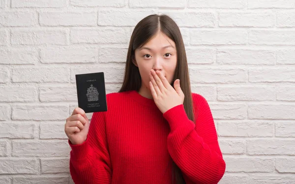 Jovem Chinesa Sobre Parede Tijolo Segurando Passaporte Canadá Cobrir Boca — Fotografia de Stock