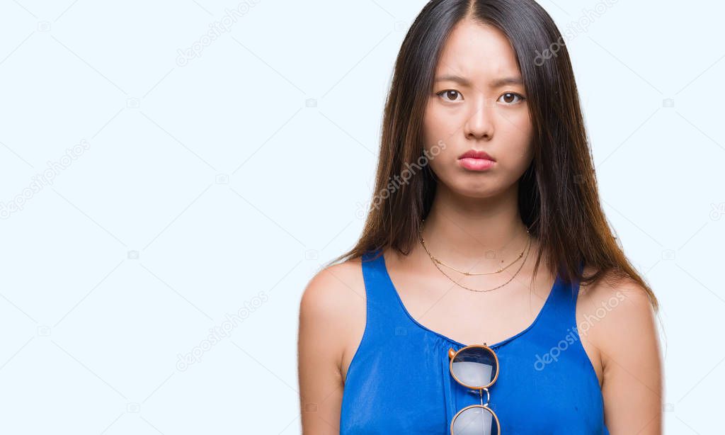 Young asian woman over isolated background skeptic and nervous