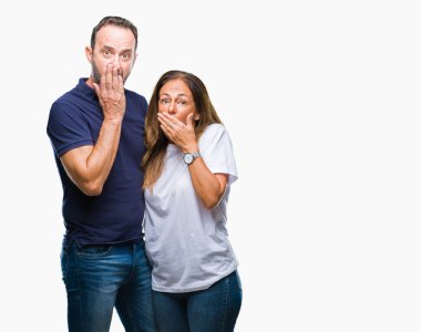 Orta yaş İspanyol rahat çift izole arka plan ağız hata için elleriyle kapsayan şok üzerinde. Gizli kavramı.