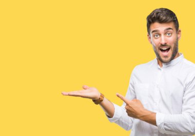 Yakışıklı delikanlı üzerinden hayran ve el ile sunulması ve parmak ile işaret ederken kameraya gülümseyen izole arka plan.