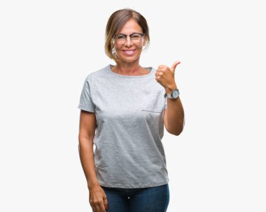 Seyir ve başparmak yanında yukarıyı mutlu yüz ile gülümseyen izole arka plan üzerinde gözlük takan orta yaş İspanyol kadın kıdemli.