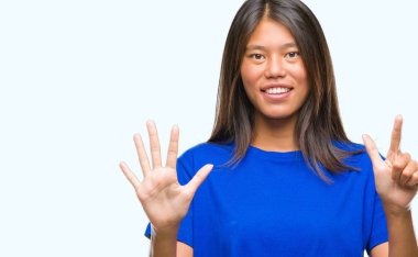 Genç Asyalı kadın gösterilen ve yedinci parmak işaret eden oktan yukarı izole arka plan üzerinde