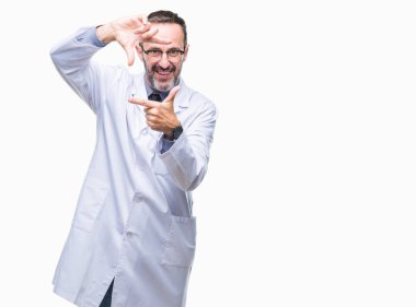 Elle yapma çerçeve ve parmakları ile mutlu yüz gülümseyen izole arka plan üzerinde beyaz önlük giyen orta yaş üst düzey ağarmış profesyonel adam. Yaratıcılık ve Fotoğrafçılık kavramı.