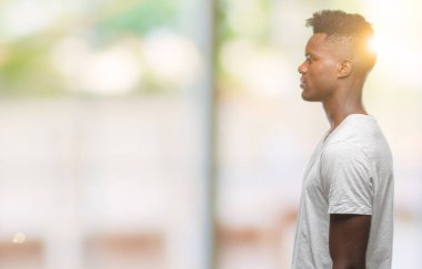 İzole arka tarafına, arayan genç Afro-Amerikan adam sakin ol kendine güvenen gülümseme ile doğal yüz pozuyla profili.