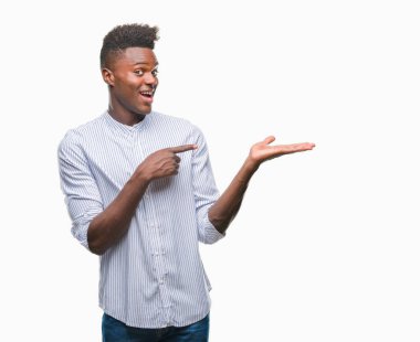 Genç Afro-Amerikan adam üzerinden hayran ve el ile sunulması ve parmak ile işaret ederken kameraya gülümseyen izole arka plan.