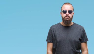 Genç beyaz hipster adam yüzünde ciddi bir ifade ile izole arka plan üzerinde güneş gözlüğü takıyor. Basit ve doğal kameraya bakıyor.