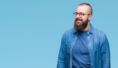 Üzerinde gözlük takan Genç beyaz hipster adam arka plan uzak tarafına gülümseme ile yüzünde, doğal ifade arıyorum izole. Kendine güvenen gülüyor.