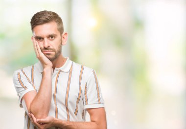 İzole arka plan düşünme seyir üzerinde genç yakışıklı adam yorgun ve sıkılmış çapraz silah depresyon sorunları ile.