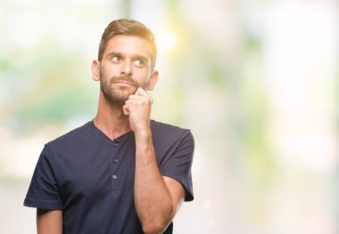 Yakışıklı delikanlı çene düşünme hakkında soru, dalgın ifade üzerine el ile izole arka plan üzerinde. Düşünceli yüzüyle gülümsüyor. Şüphe kavramı.