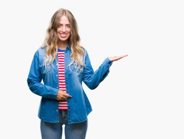 Neşeli sunulması ve kameraya bakarak avucunun ile işaret gülümseyen izole arka plan üzerinde sarışın güzel genç kadın.