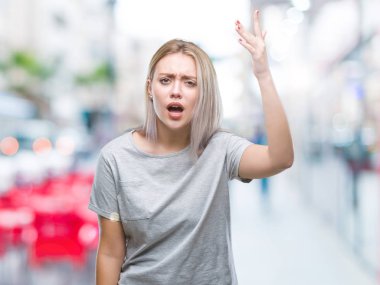 Genç Sarışın kadın izole arka plan öfkeli ve sinirli sinirli ve öfke ile bağırarak süre öfkeli yumruk yükselterek yüzünden. Öfke ve agresif kavramı.