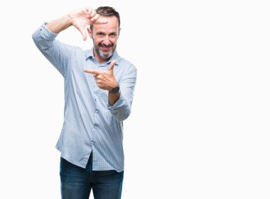 Orta yaş ağarmış üst düzey iş adamı elle yapma çerçeve ve parmakları ile mutlu yüz gülümseyen izole arka plan üzerinde. Yaratıcılık ve Fotoğrafçılık kavramı.