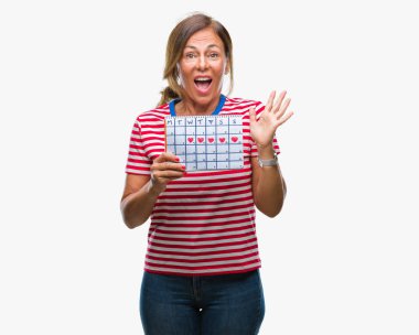 Adet takvim tutan orta yaş üst düzey İspanyol kadın büyük gülümseme ile çığlık zaferini kutluyor ve ellerini kaldırdı arka plan çok mutlu ve heyecanlı, kazanan ifade izole