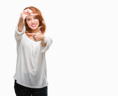 Genç güzel kadın elle yapma çerçeve ve parmakları ile mutlu yüz gülümseyen izole arka plan yüzünden. Yaratıcılık ve Fotoğrafçılık kavramı.