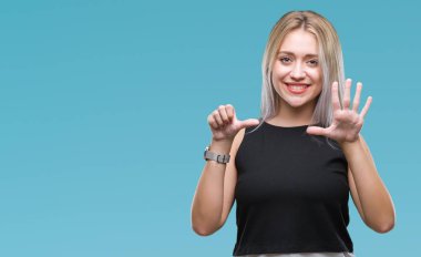 Sarışın genç kadın gösterilen ve parmakları ile işaret izole arka plan üzerinde kendinden emin ve mutlu gülümseyerek süre 6 numara.