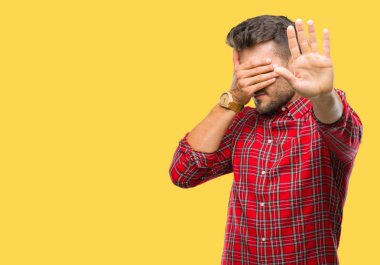 Genç yakışıklı adam izole elleriyle gözlerini kapsayan arka plan ve stop jest ile acı ve korku ifadesi. Utandım ve negatif kavramı.