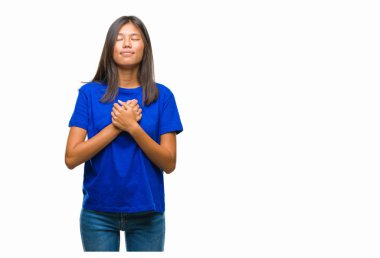 Elleri göğsünde kapalı gözler ile gülümseyen Genç Asyalı kadın 