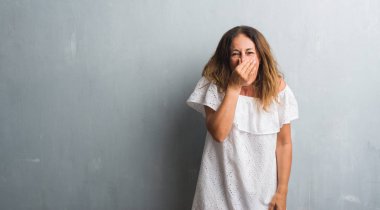 Duran bir şey pis ve iğrenç kokulu gri grunge duvar, dayanılmaz koku, holding nefes burun parmak ile orta yaş İspanyol kadın. Kötü kokuyor kavramı.