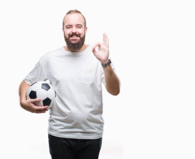 Parmak, mükemmel sembolü ile ok işareti yapıyor izole arka plan üzerinde futbol futbol topu tutan genç beyaz hipster adam