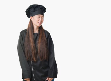 Genç Çinli kadın şefi Tekdüzen uzak tarafına gülümseme ile yüzünde, doğal ifade hastalarına giyen arka plan izole. Kendine güvenen gülüyor.