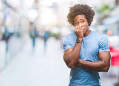 Afro Amerikalı adam stresli ve gergin ile izole arka plan üzerinde tırnak ısırma dudaklarından eller. Anksiyete sorunu.