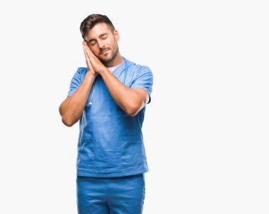 Genç yakışıklı Doktor cerrah adam yorgun hayal ve ile gülümseyen gözleri kapalı iken ellerle birlikte poz uyku izole arka plan.