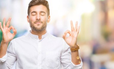 Yakışıklı delikanlı izole arka plan üzerinde dinlenmek ve gülümseyen gözlerle parmak ile meditasyon jest yapıyor kapalı. Yoga kavramı.