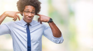 Yüksek sesle müzik gürültü rahatsız ifade parmaklarıyla kulaklarıyla kapsayan izole arka plan üzerinde gözlük takan Afro Amerikan iş adamı. Sağır kavramı.