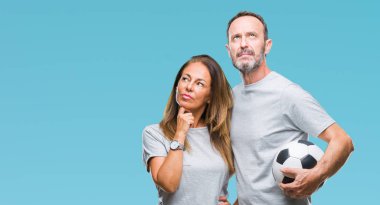 Soru, çok karışık fikir hakkında düşünme futbol futbol topu izole arka plan üzerinde ciddi tutan orta yaş İspanyol çift yüz