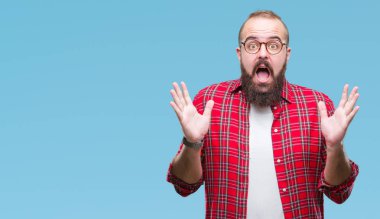 Üzerinde gözlük takan Genç beyaz hipster adam deli kutluyor arka plan izole ve çığlık kaldırdı ve açık gözleri heyecanlı silah ile başarı için hayrete düşürdü. Kazanan kavramı