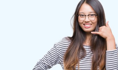 İşin gülümseyen Genç Asyalı kadın telefon hareketi el ile 