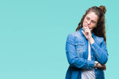 Güzel genç esmer kıvırcık saçlı kız gözlüklü düşünme izole arka plan bakmaktan yorgun ve sıkılmış çapraz silah depresyon sorunları ile.