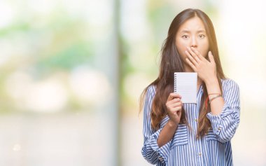 Defter izole arka plan üzerinde tutan Genç Asyalı kadın 