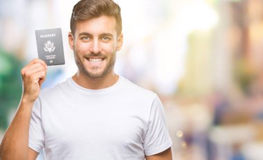 Amerika Birleşik Devletleri pasaport ayakta ve diş gösterilen kendine güvenen bir gülümsemeyle gülümseyerek mutlu bir yüz ile izole arka plan üzerinde tutan genç yakışıklı adam