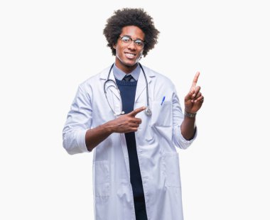 Gülümseyen ve iki elleri ve parmakları ile tarafına işaret kamera bakarak izole arka plan Afro Amerikalı doktor adam.