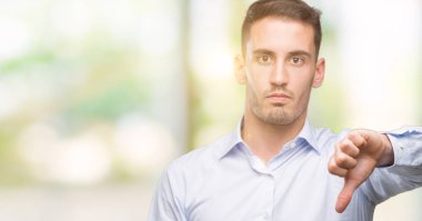 Mutsuz ve kızgın ret gösterilen ve başparmak aşağı hareketi ile negatif seyir yakışıklı genç iş adamı. Kötü ifade.