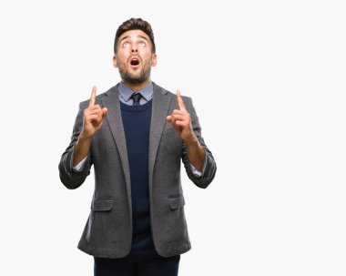 Genç yakışıklı iş adamı izole arka plan üzerinden hayran ve yukarıya bakıp parmakları ile işaret şaşırttı ve silah kaldırdı.