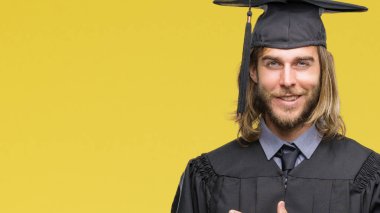 İzole arka neşeli bir gülümseme ile el ve parmak kadar kameraya bakarak yüzündeki mutlu ve doğal ifade ile yan ile işaret yüz üzerinden uzun saçlı Genç mezun yakışıklı.