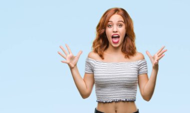 Genç güzel kadın deli kutluyor ve silah ile başarı için heyecanlı çığlık kaldırdı ve açık gözleri hayret izole arka plan yüzünden. Kazanan kavramı