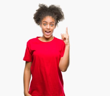 Başarılı fikirle parmağı yukarıyı izole arka plan üzerinde genç afro Amerikalı kadın. Çıktıktan ve mutlu. Bir numara.